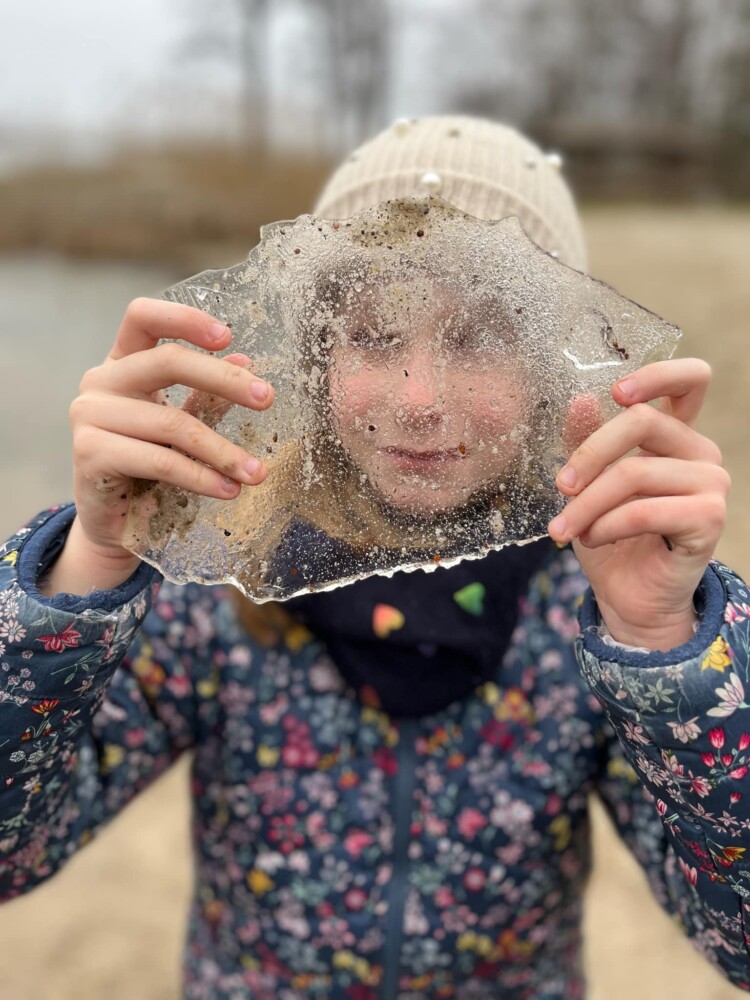 Fotografia przedstawia dzieci, które pieką kiełbaski przy ognisku.