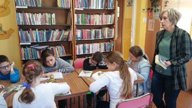 dzieci czytają ksiązki w bibliotece