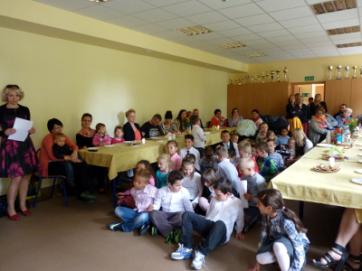 sala wypełniona stołami, dziećmi i dorosłymi