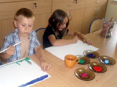 dzieci maluja farbami na kartkach