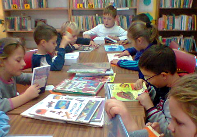 dzieci czytają w bibliotece